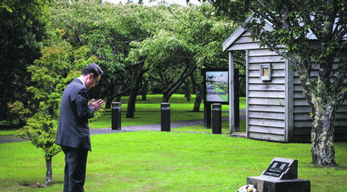 Acting Japanese Ambassador Tatsushi Nishioka bowing and laying a wreath at the 80th anniversary of the Featherston Incident, a riot which led to the deaths of 48 Japanese POWs and a guard.